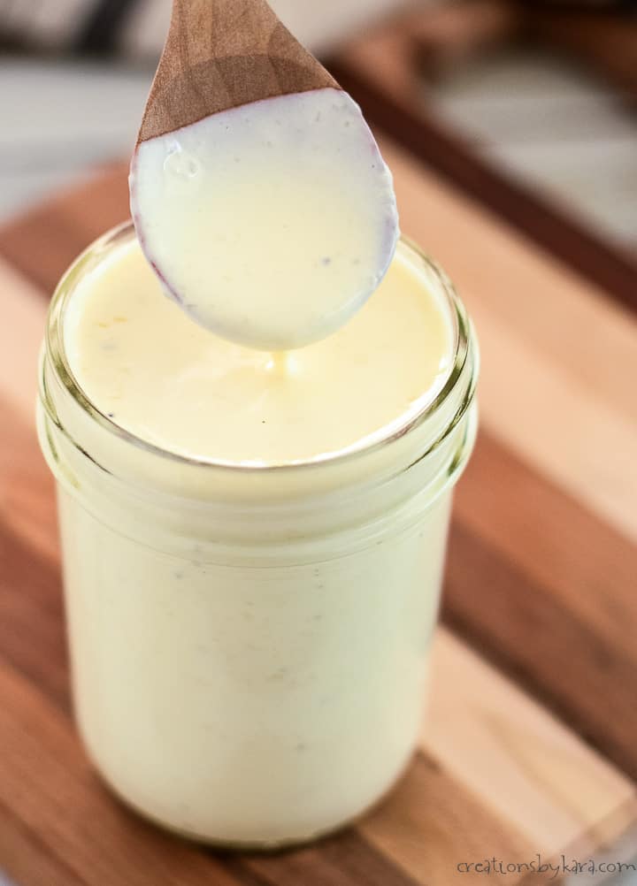 jar of low carb alfredo sauce with a wooden spoon