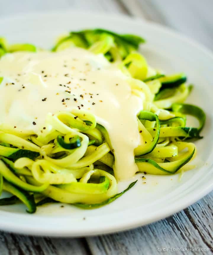 gluten free alfredo sauce over a plate of zoodles