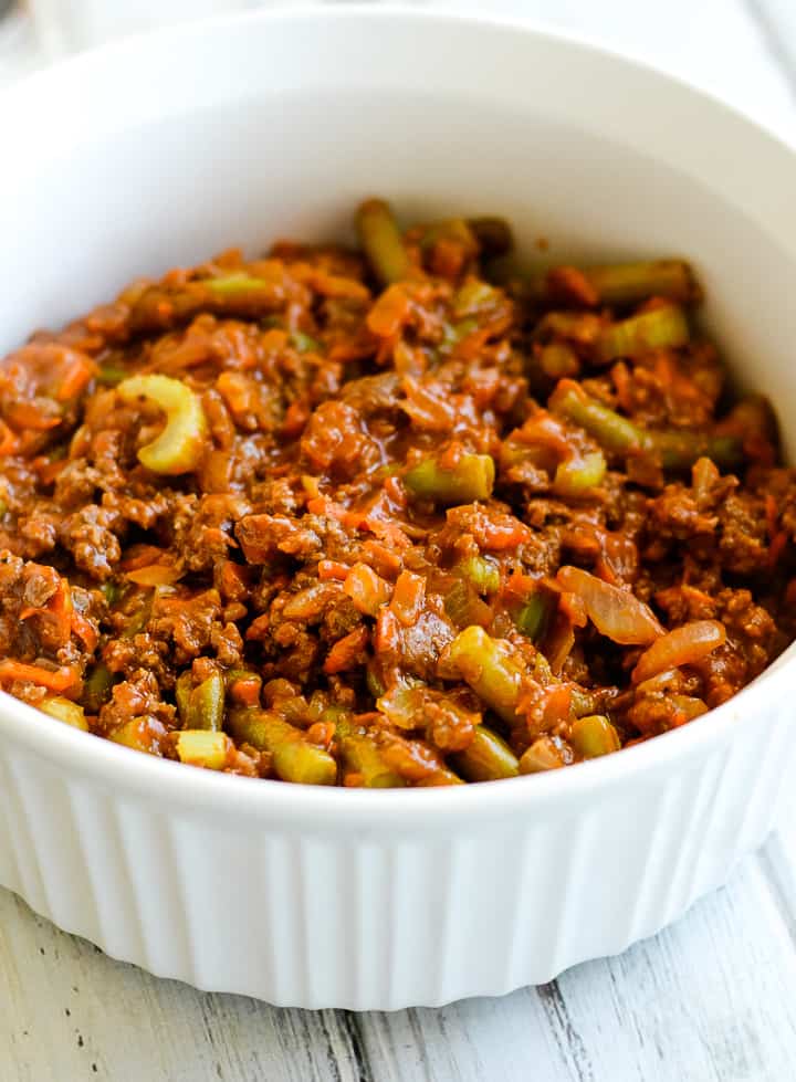 meat and vegetable mixture in a white casserole dish