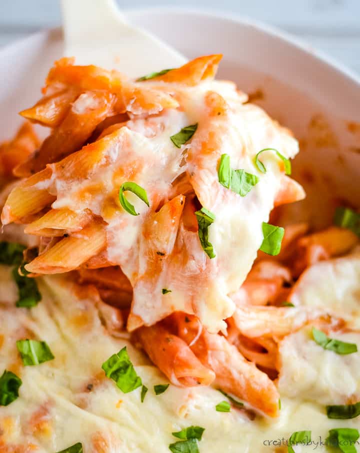 scoop of baked penne pasta with cheese