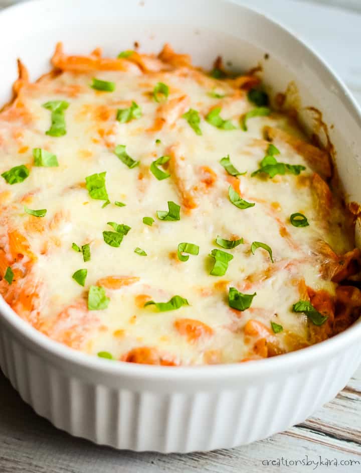 easy pasta bake in a white casserole dish topped with fresh basil