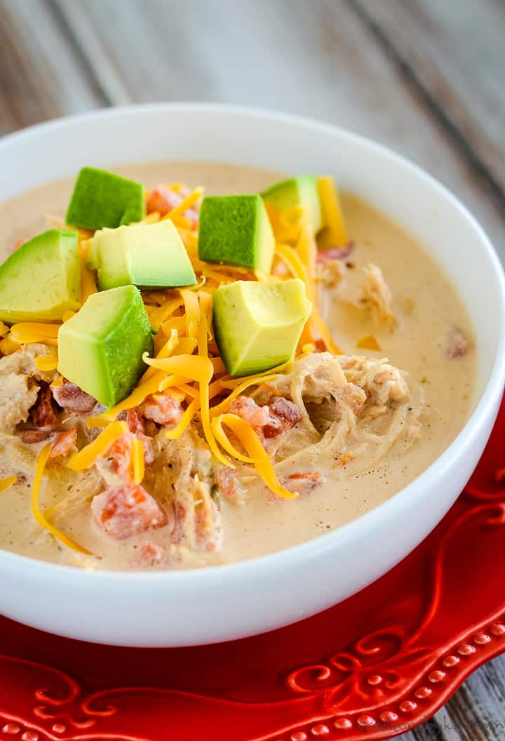 bowl of creamy chicken enchilada soup with cheese and avocados