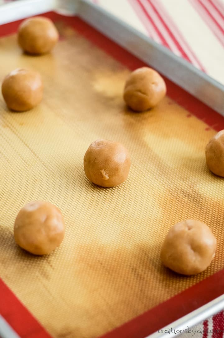 peanut butter snicker cookie dough balls on a baking sheet