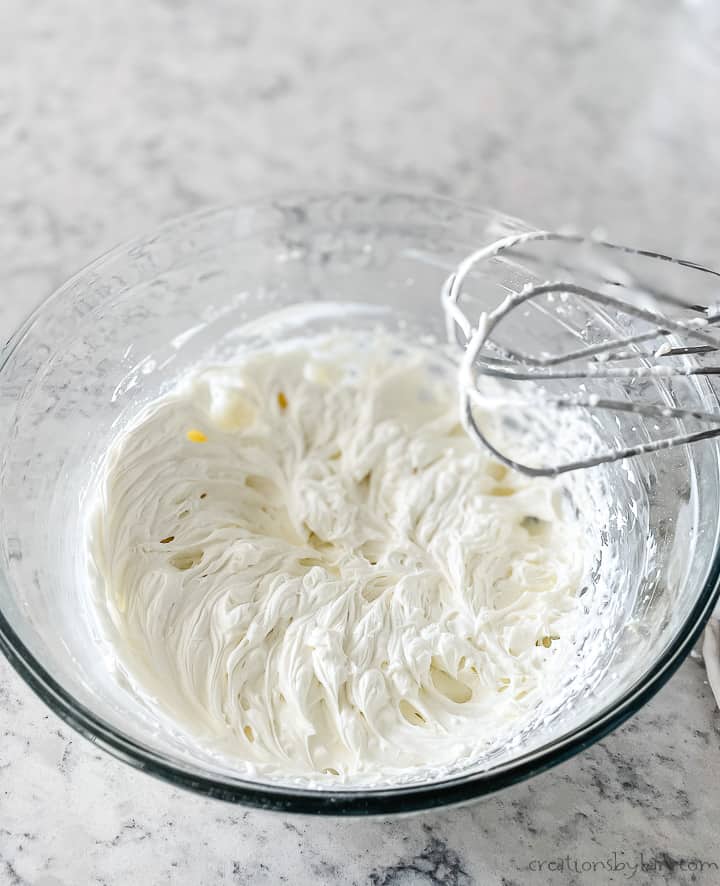 bowl of whipped cream with beaters