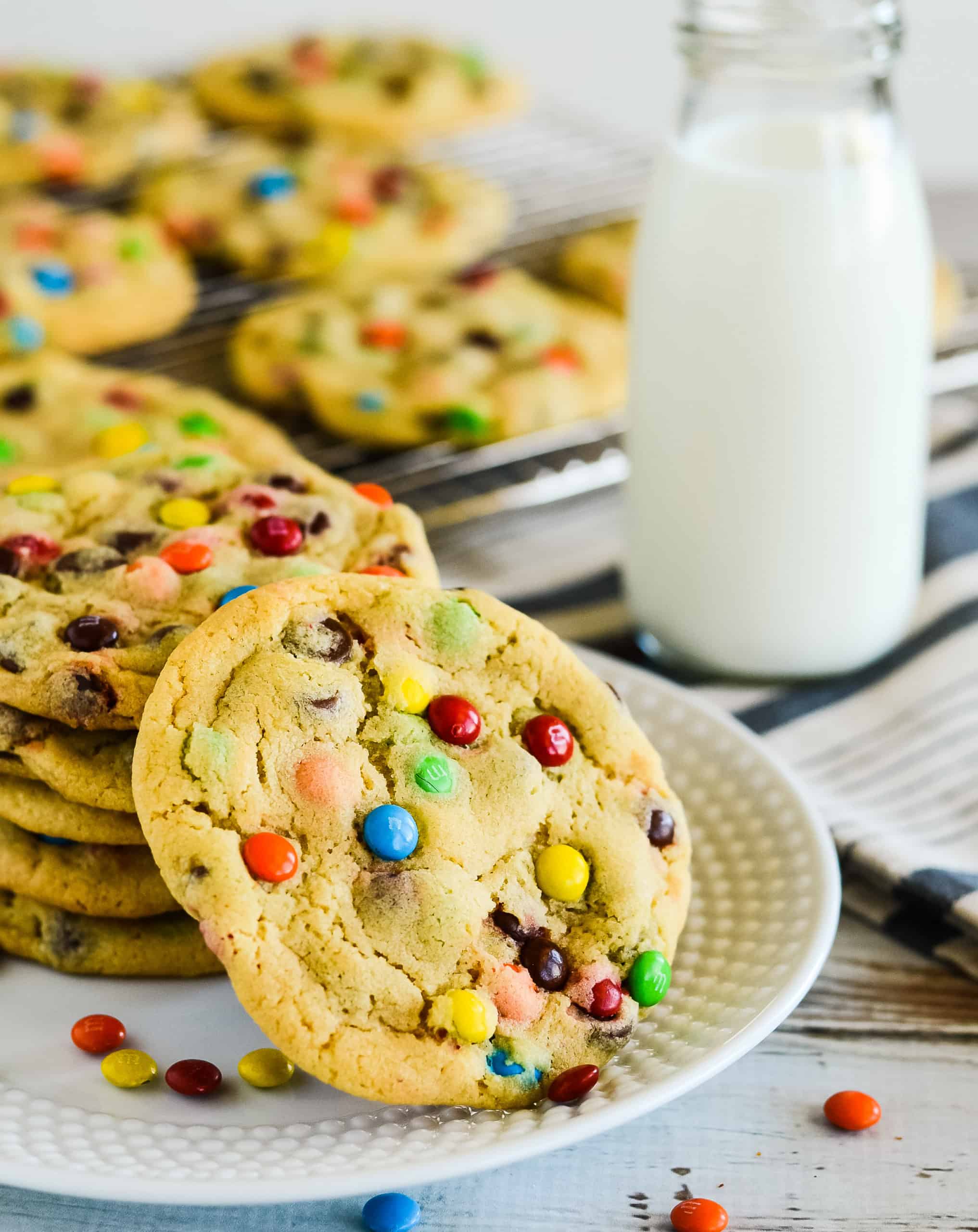 cookies on a plate with milk and more cookies in the background