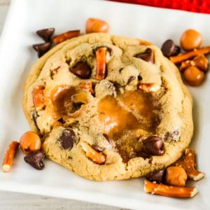 copycat panera kitchen sink cookie on a plate with pretzels, chocolate chips, and caramel bits