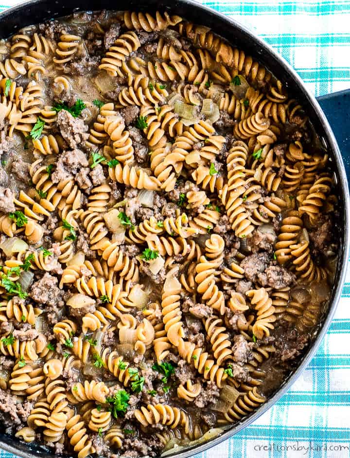 overhead shot of skillet of one pot ground beef rotini stroganoff garnished with parsley