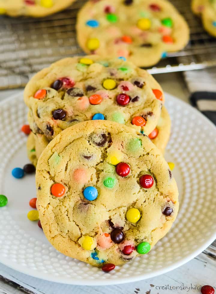 large M&M chocolate chip cookies on a plate with cookies in the background
