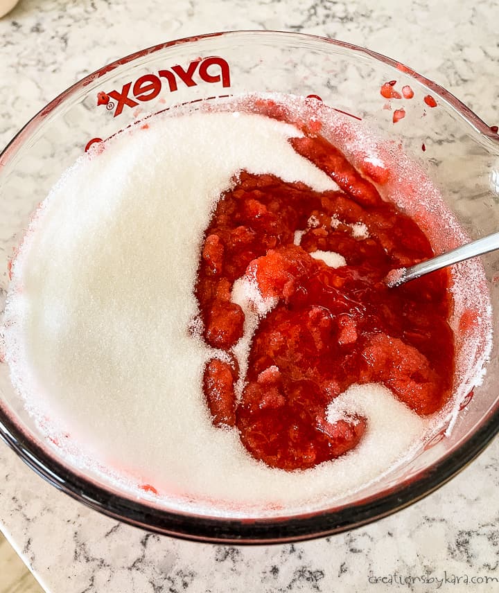 process shot - stirring sugar into homemade strawberry jam