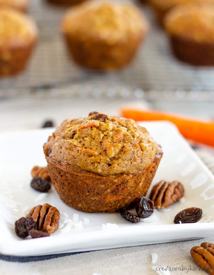 morning glory muffin on a white plate with nuts, raisins, and coconut