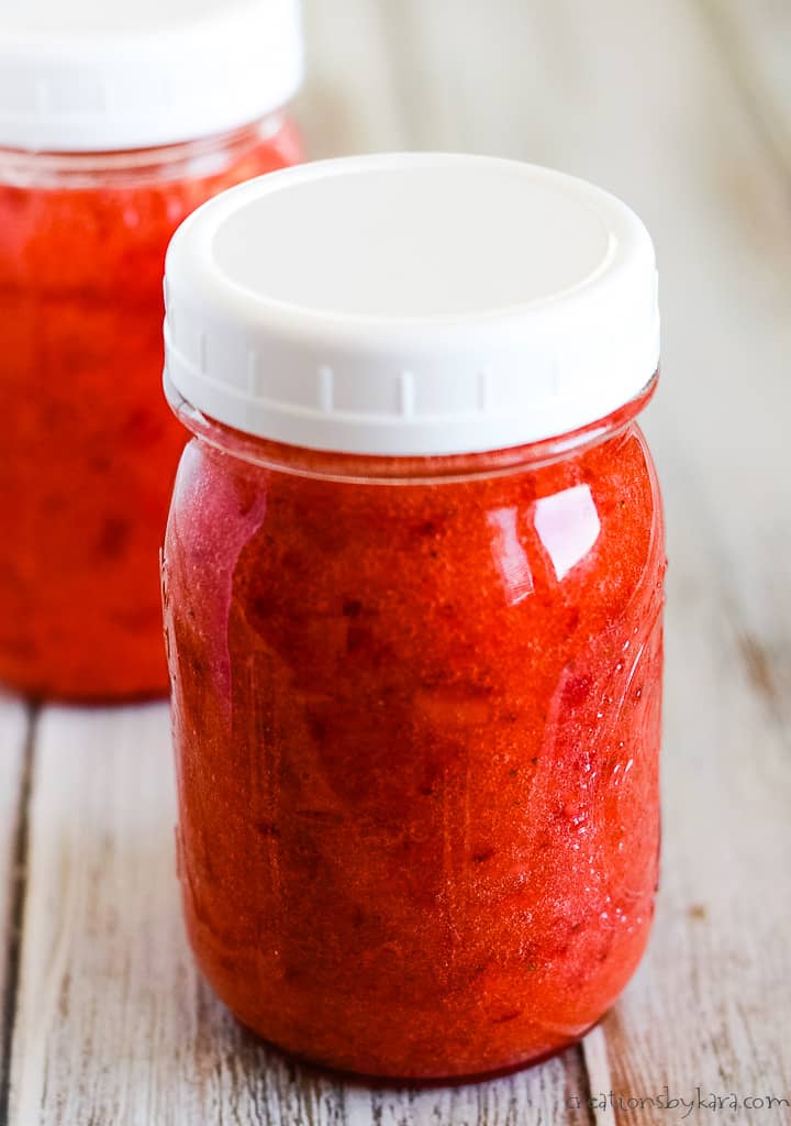 mason jar of strawberry freezer jam with a white lid