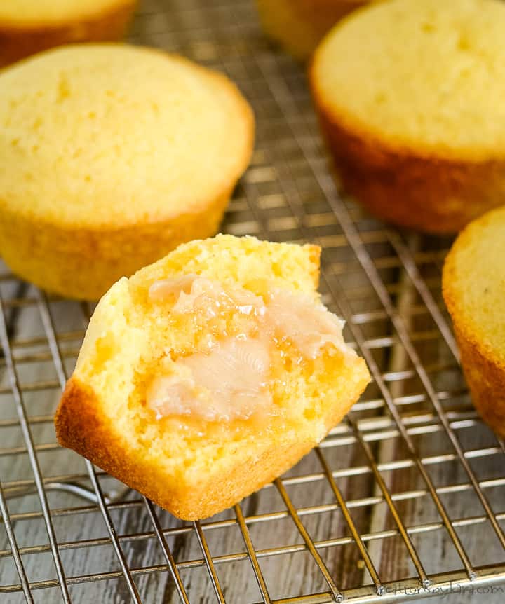 split corn bread muffin with honey butter on a cooling rack