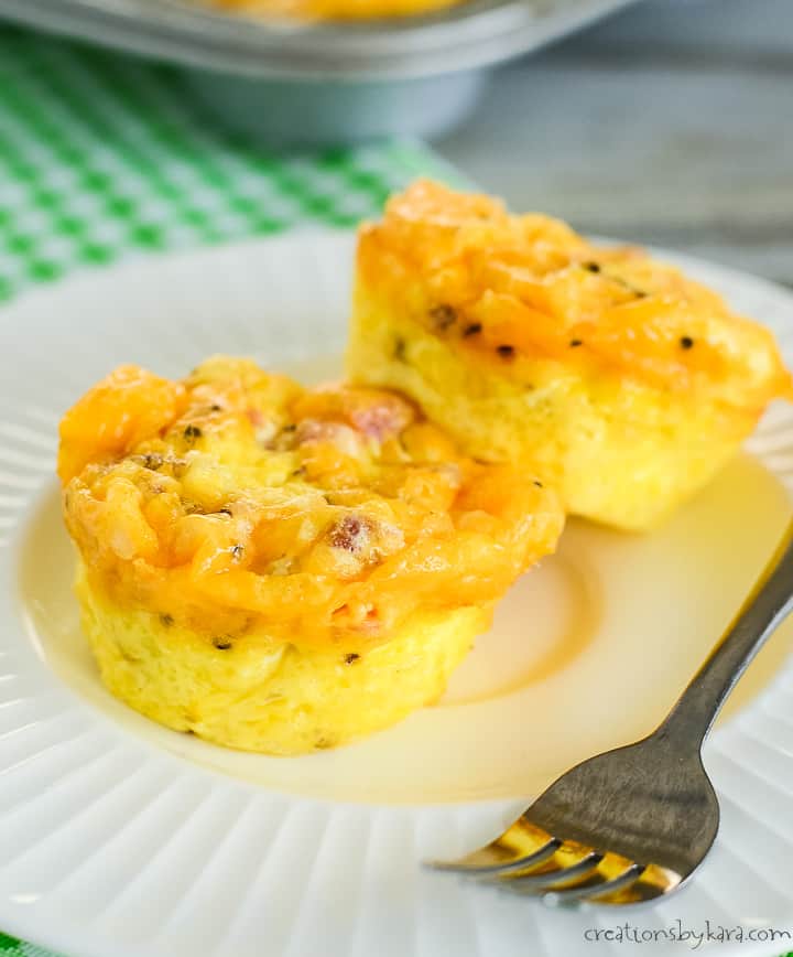 plate with two baked egg cups with cheese and ham