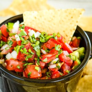 bowl of fresh salsa with a tortilla chip in it