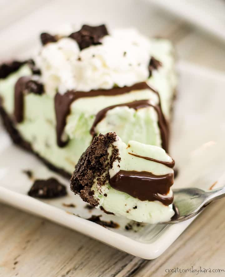 forkful of grasshopper ice cream pie with a plate of pie in the background