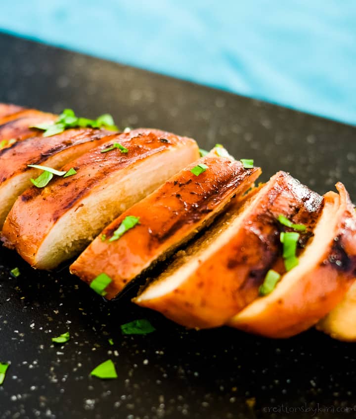 soy sauce marinade chicken breast sliced on a cutting board