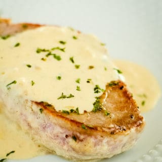 pork chop on a plate covered with pork chop sauce