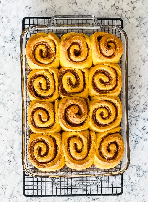 pan of sweet rolls on a wire cooling rack