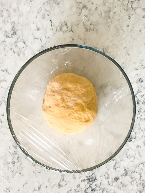 bowl of dough covered with plastic wrap