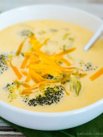 bowl of keto cheddar broccoli soup garnished with shredded cheese