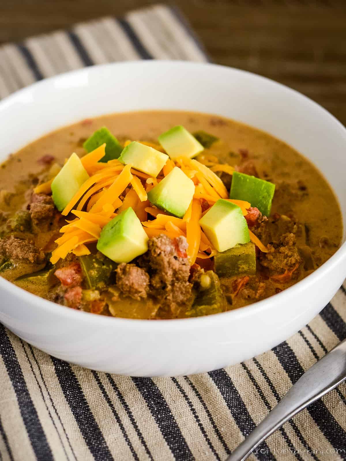 bowl of keto taco soup garnished with cheese and avocadoes