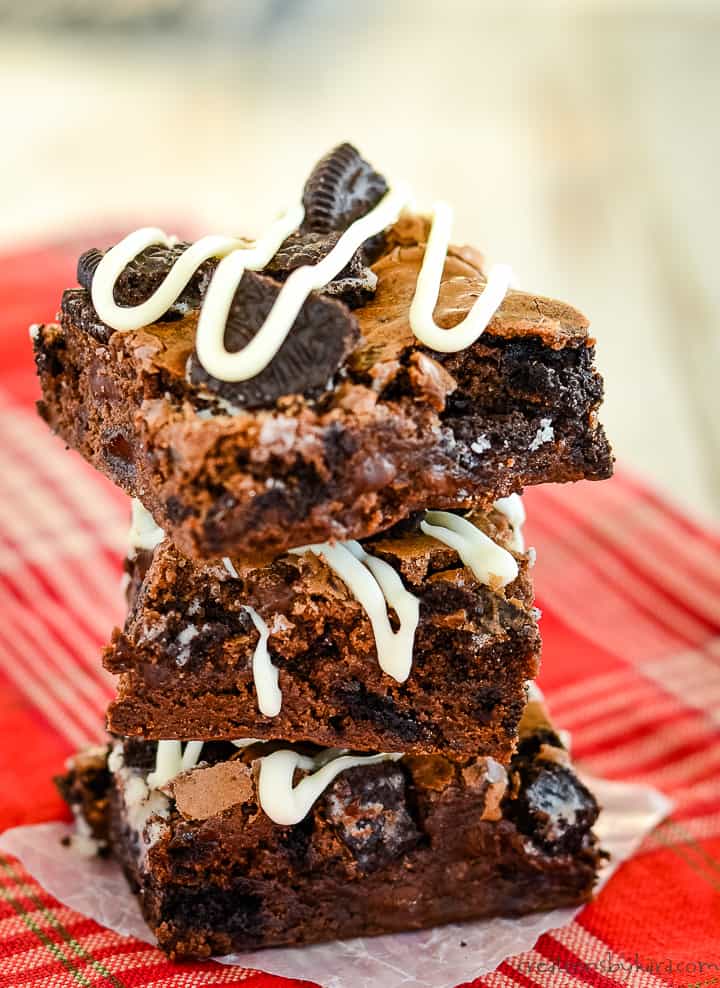 stack of cookies and cream brownies on a piece of waxed paper