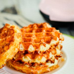 stack of chaffles with mini waffle maker in the background