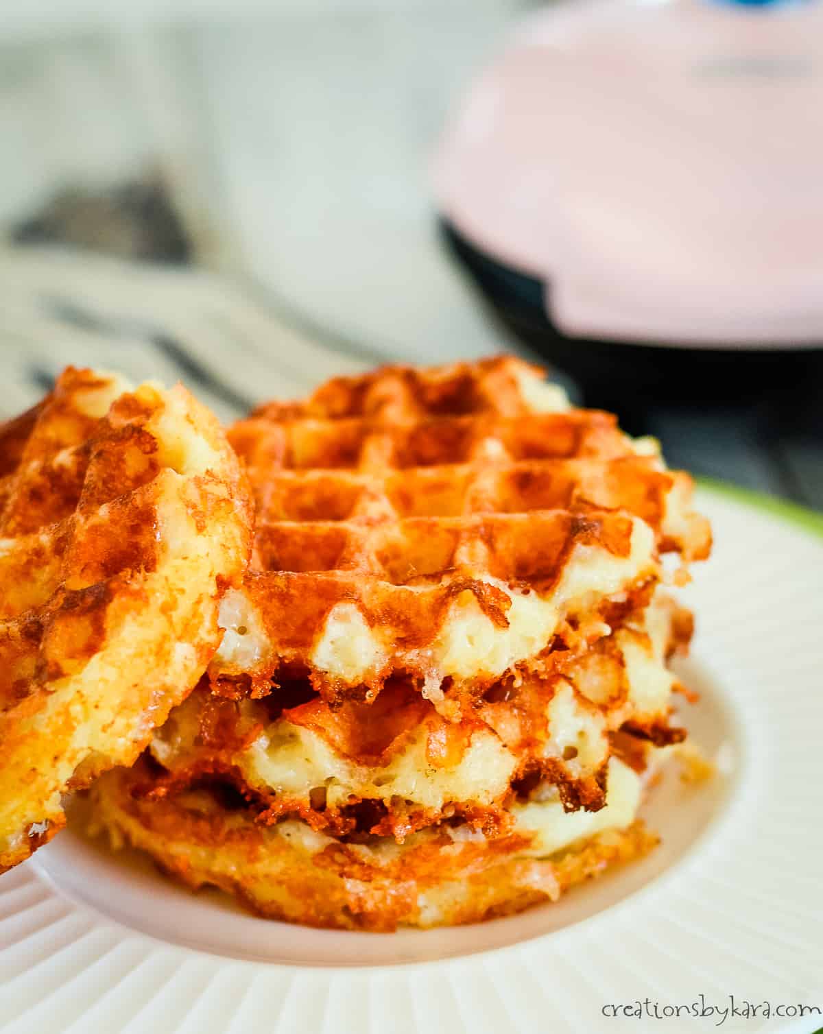 stack of chaffles with mini waffle maker in the background