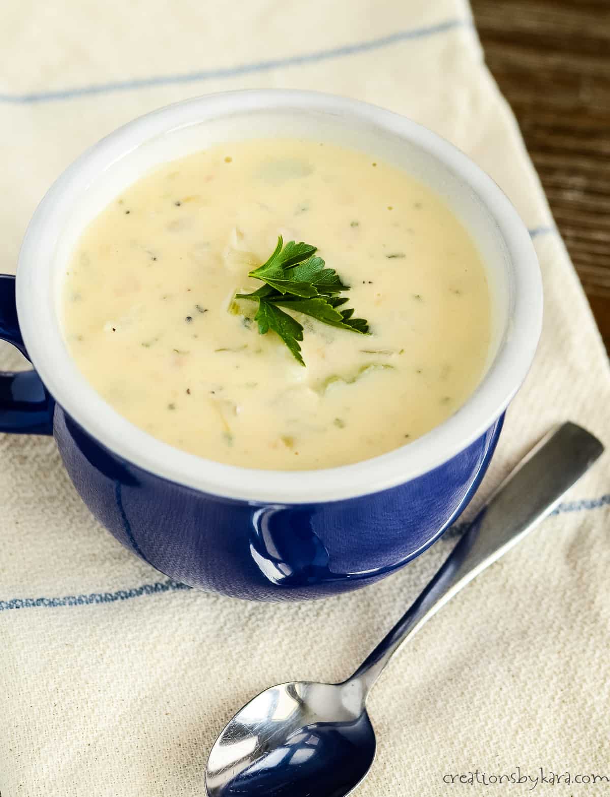 bowl of new england clam chowder garnished with parsley