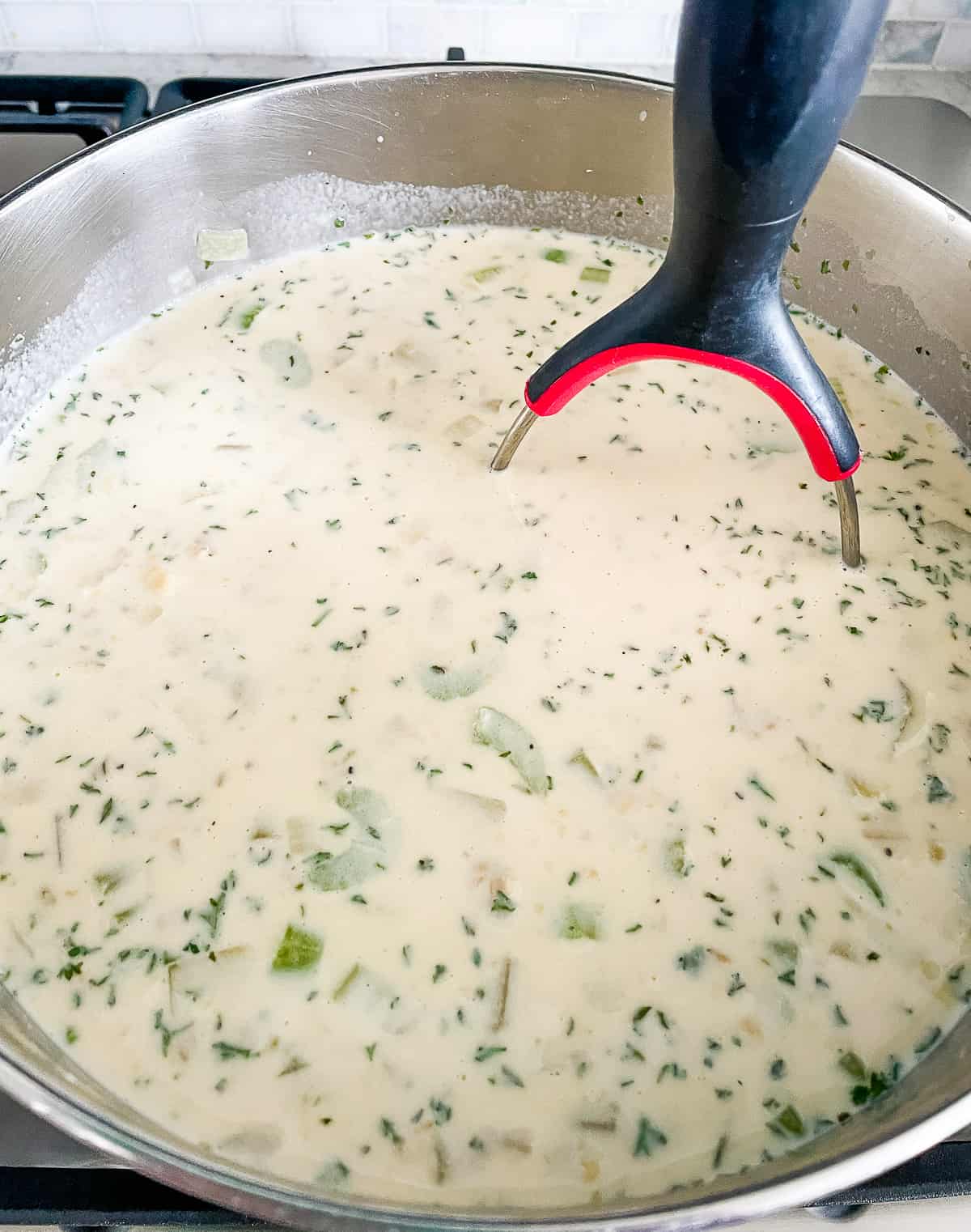 mashing potatoes in a pot of soup