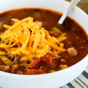 bowl of low carb hamburger soup topped with grated cheddar cheese
