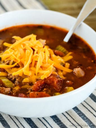 bowl of low carb hamburger soup topped with grated cheddar cheese