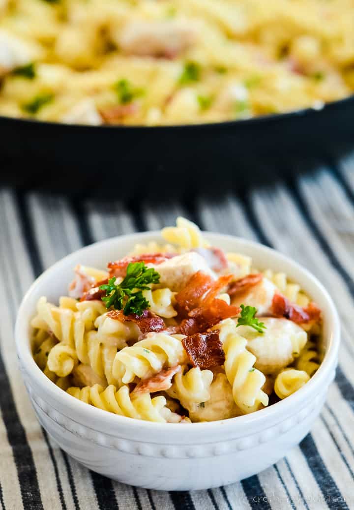 bowl of chicken bacon ranch pasta in front of a skillet