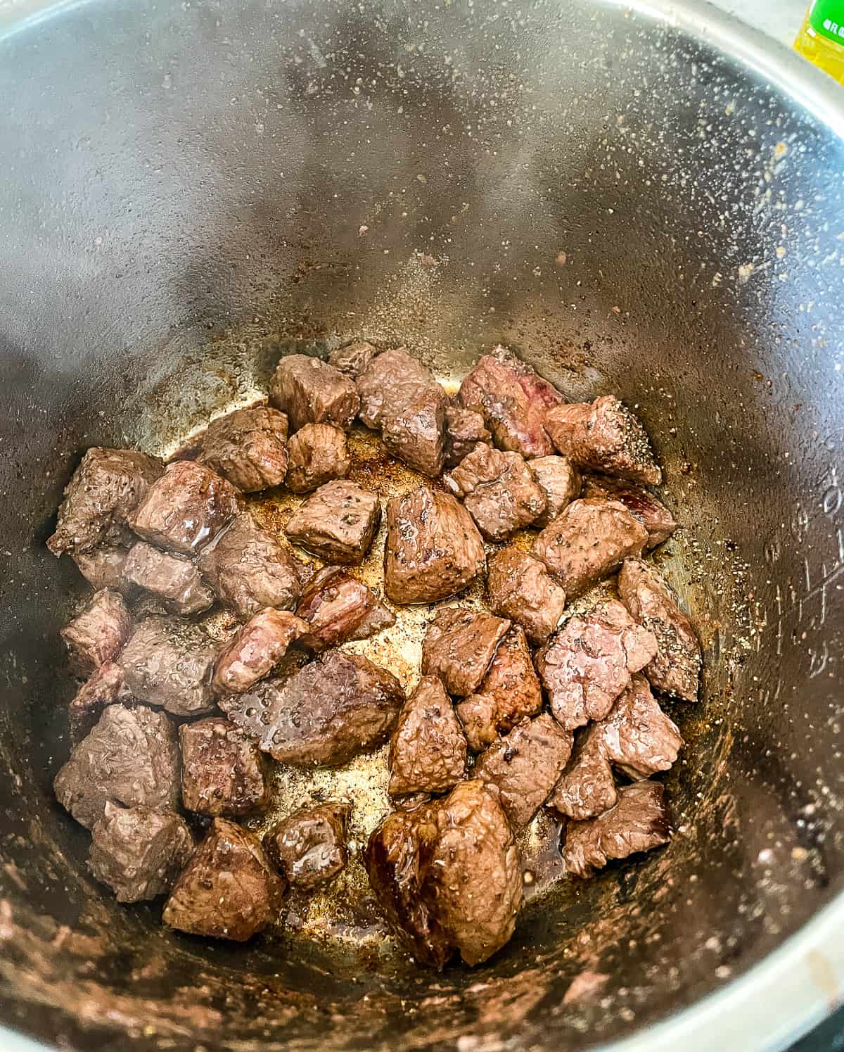 beef cubes being browned in an instant pot
