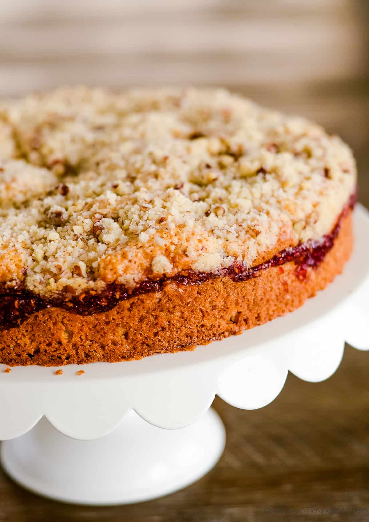 raspberry crumb coffee cake on a white cake stand