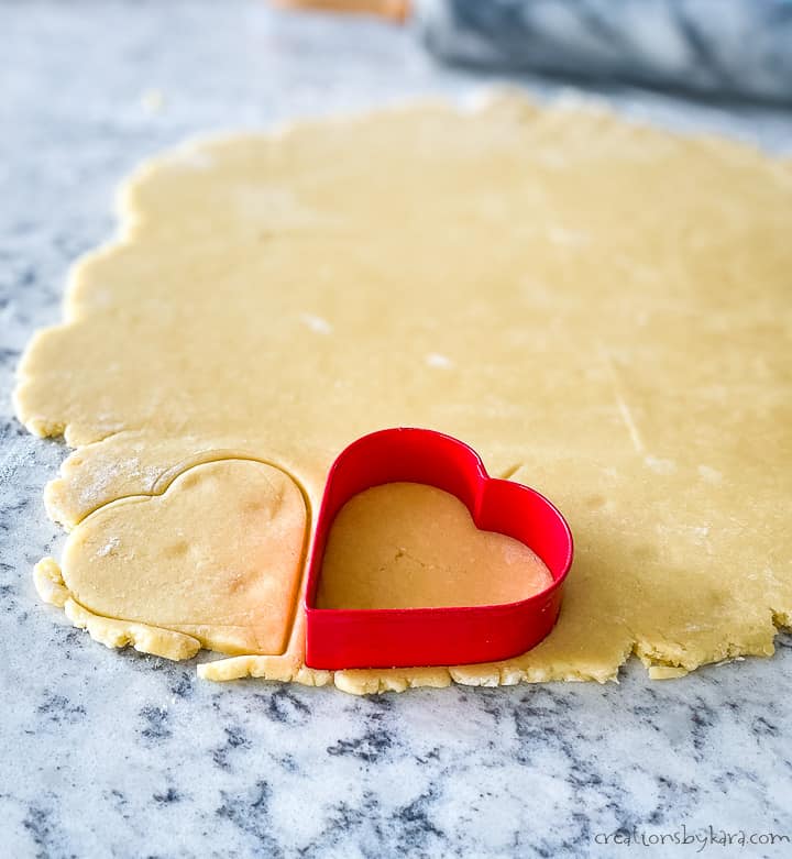 cookie dough being cut into heart shapes