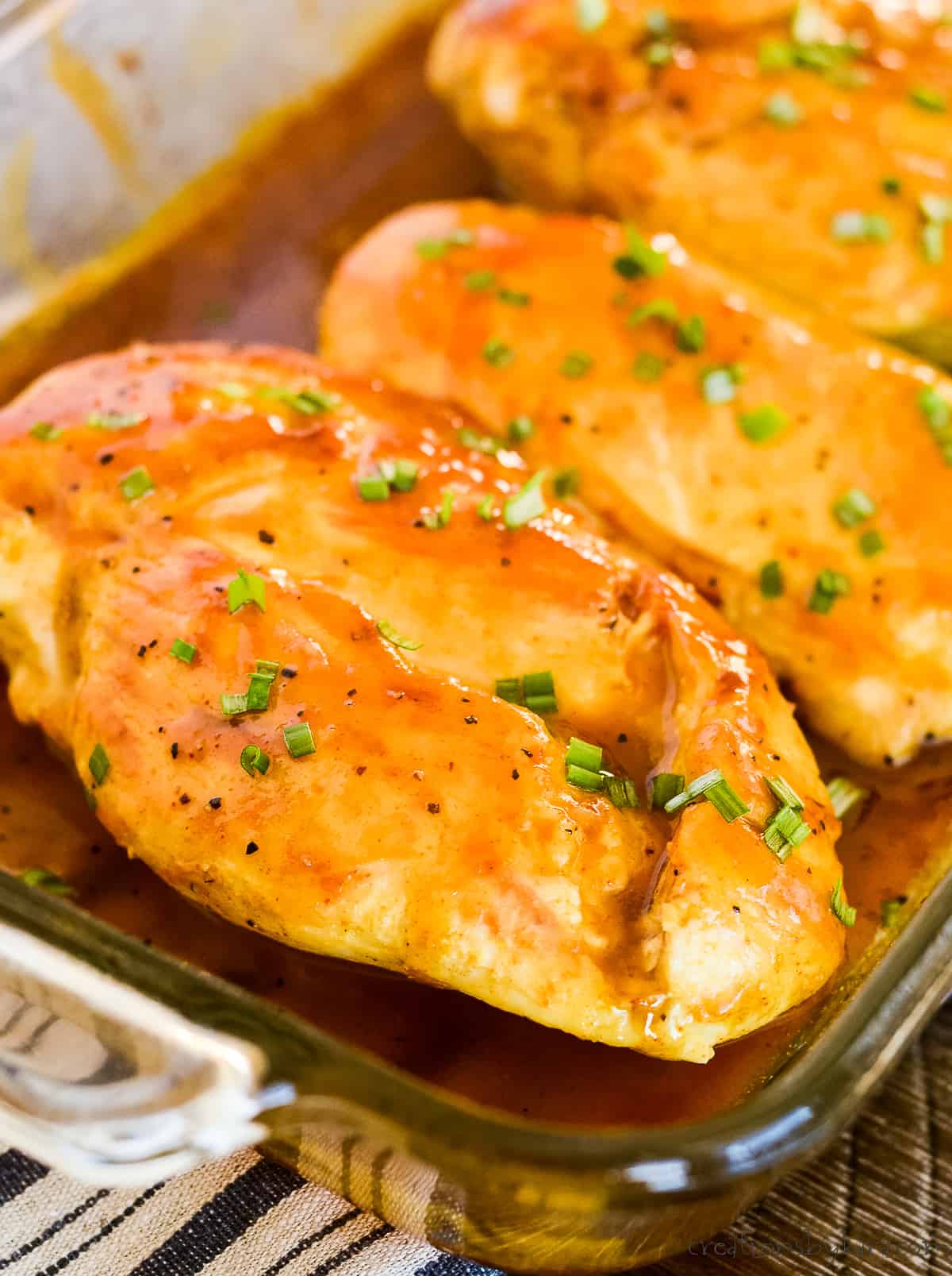 pan of honey mustard glazed chicken breast garnished with green onions
