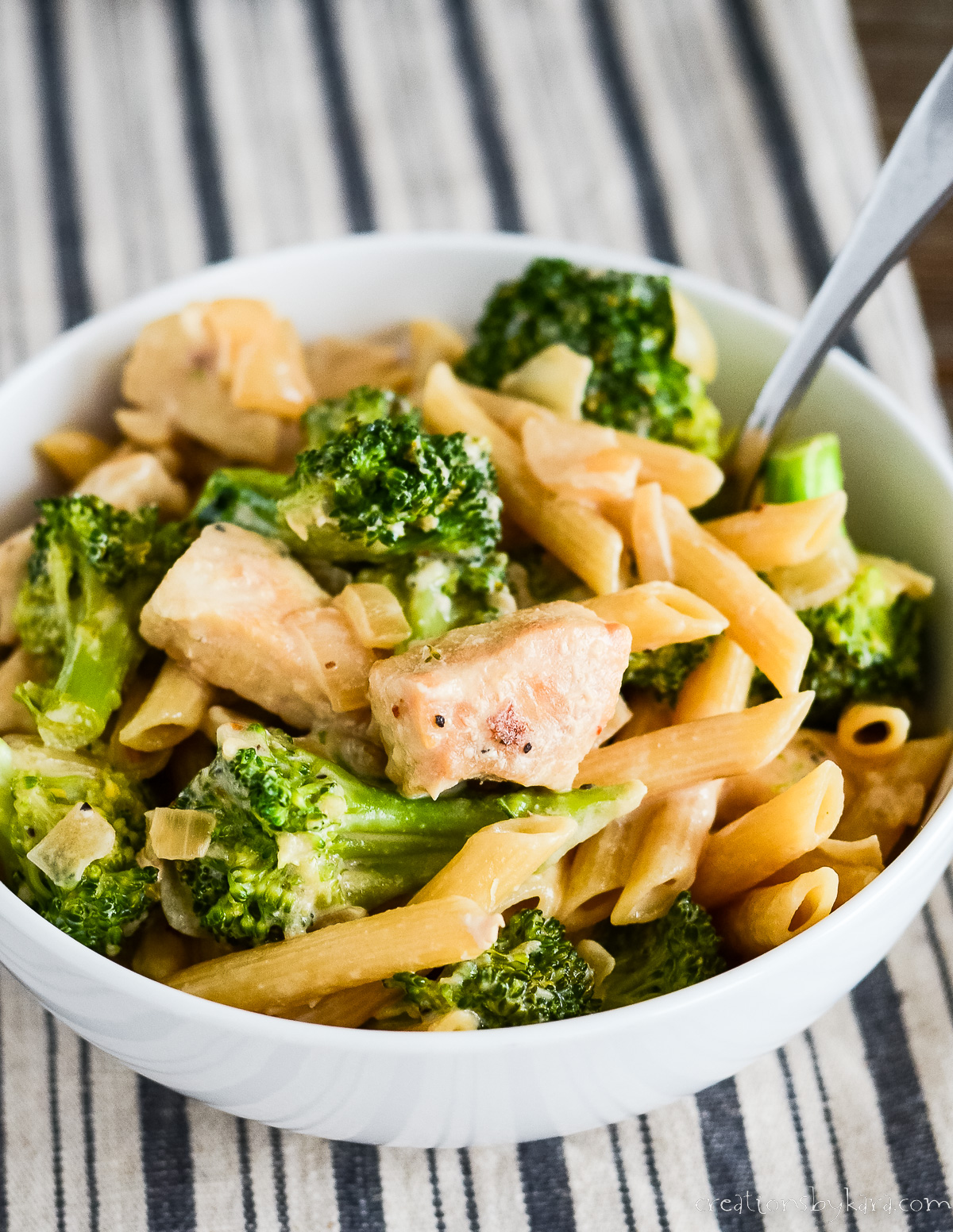 bowl of chicken and broccoli pasta with a spoon