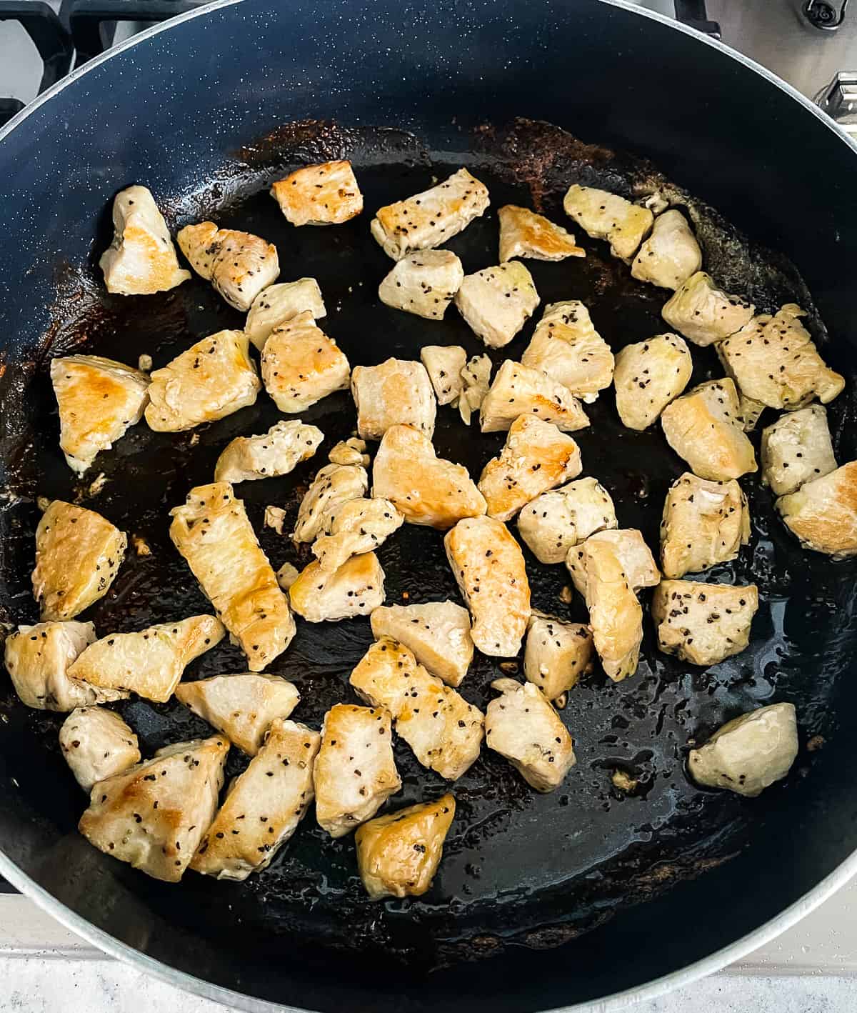 cubed chicken breast browning in a skillet
