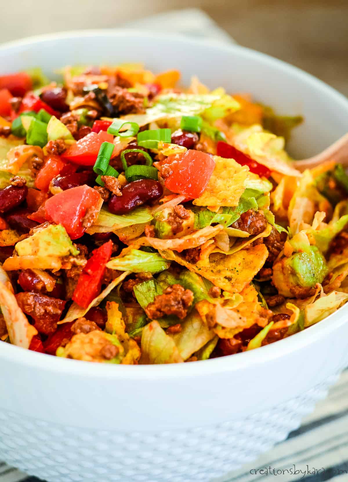 taco salad with catalina dressing and doritos in a white bowl