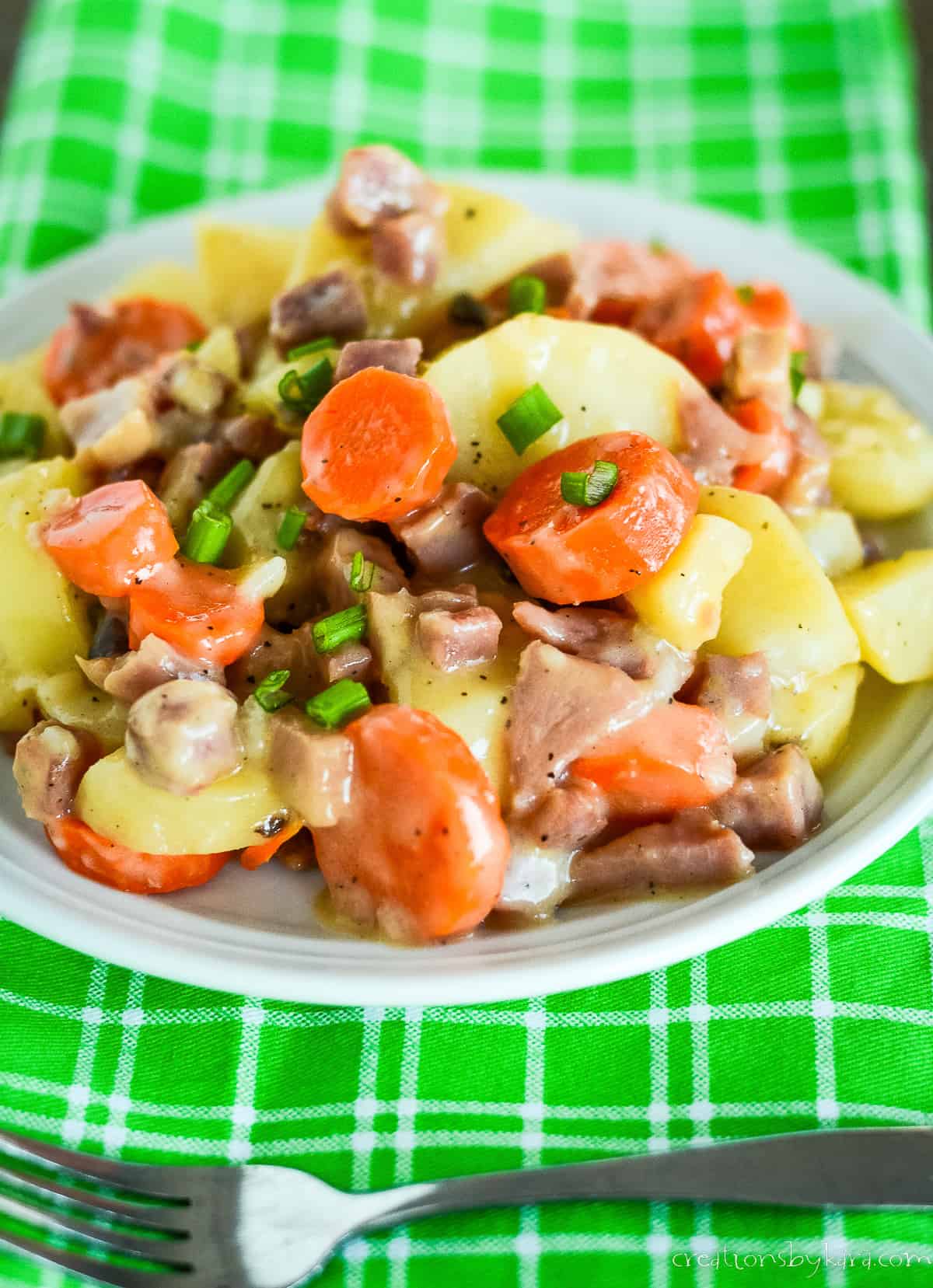 plate of ham and potato casserole with carrots