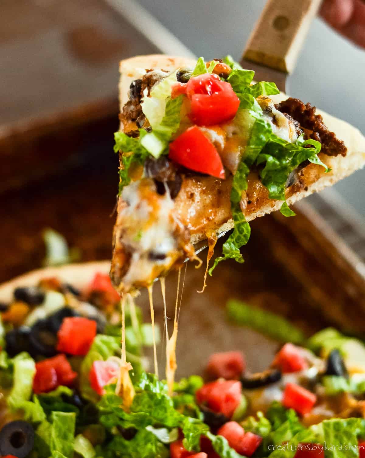 slice of taco pizza on a serving spatula