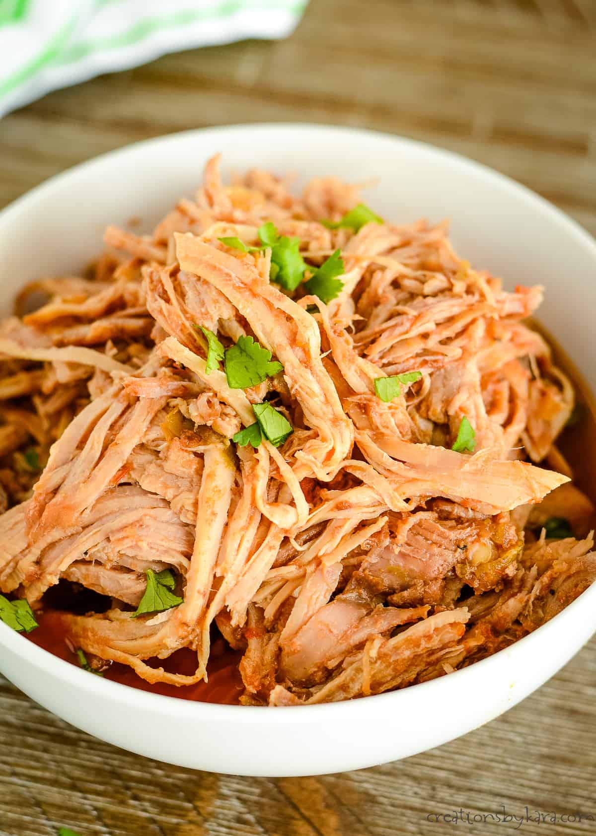 bowl of shredded sweet pork garnished with chopped cilantro