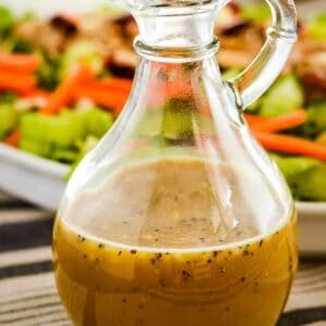 plate of salad with a cruet of honey mustard dressing