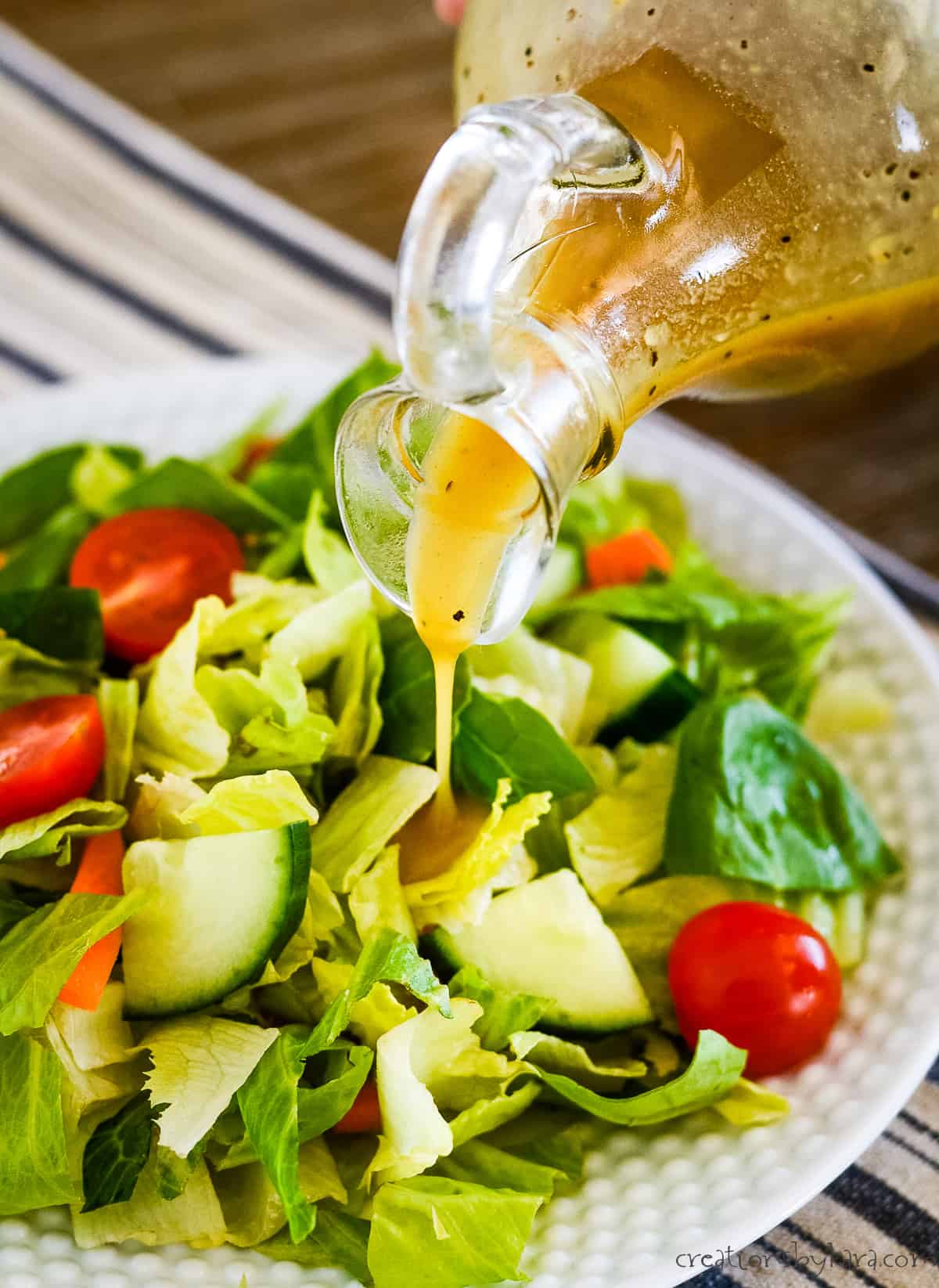 honey mustard salad dressing being drizzled out of a cruet
