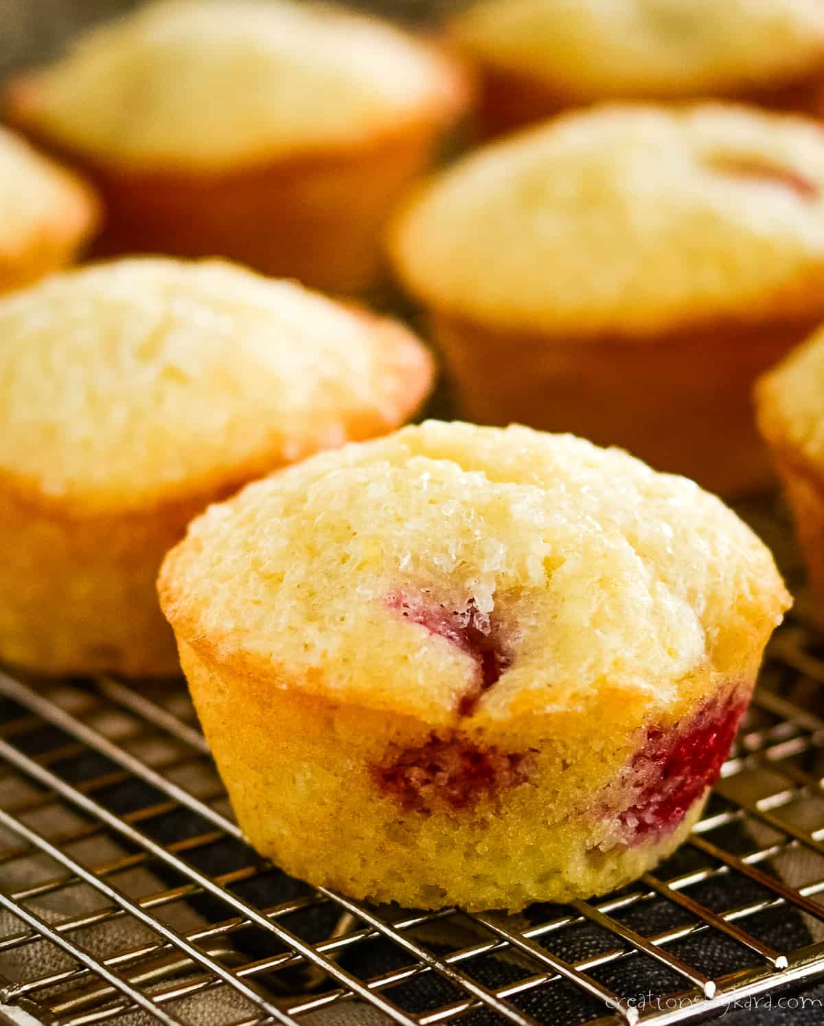 close up raspberry lemon muffin on a cooling rack