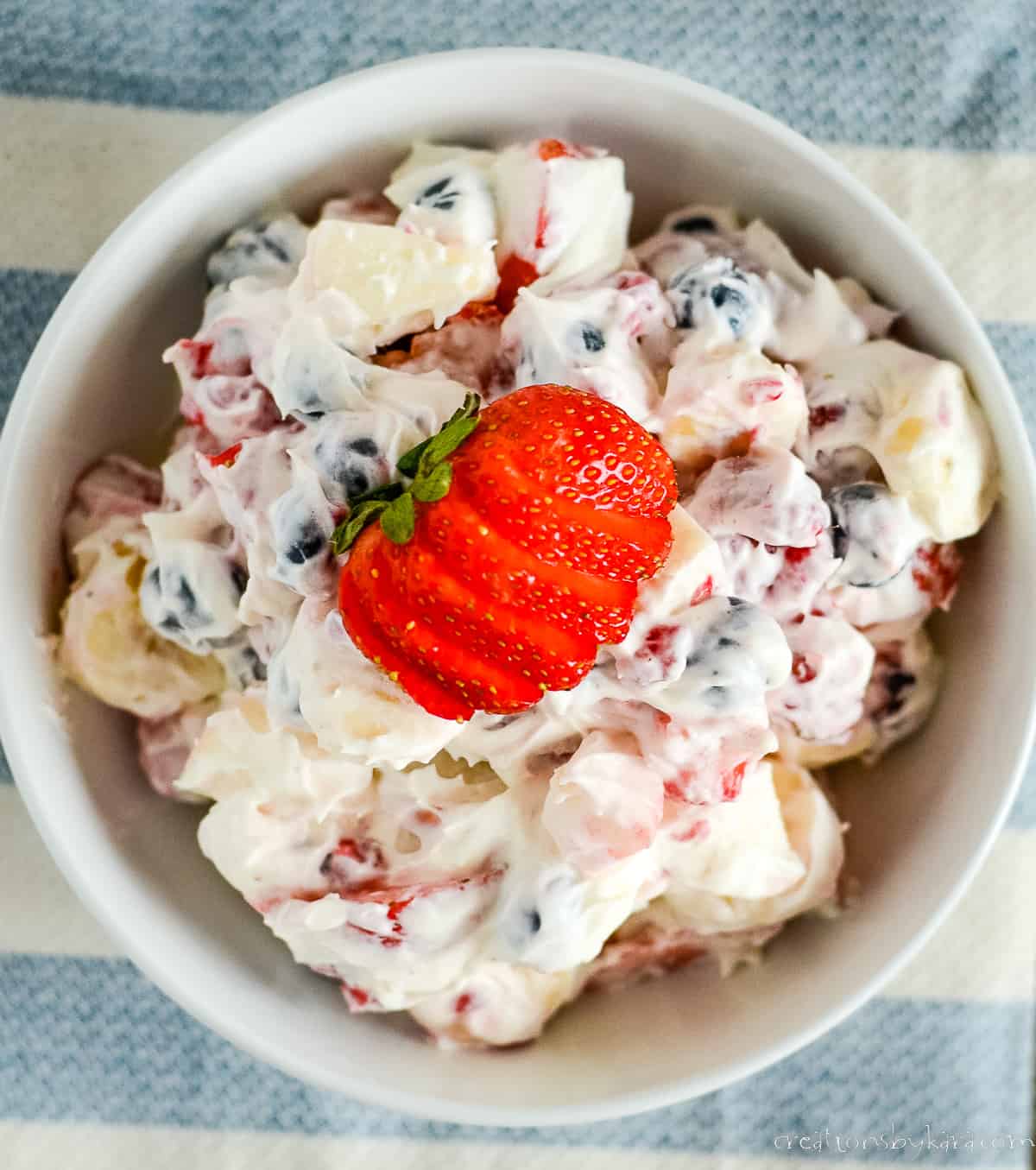 overhead shot of creamy cheesecake salad with a strawberry on top