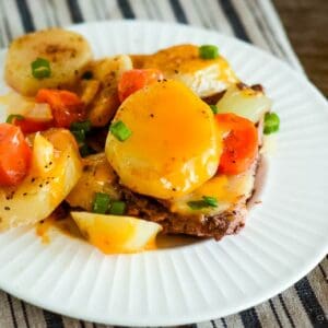 plate of cooked hamburger, potatoes, carrots and onions topped with melted cheese