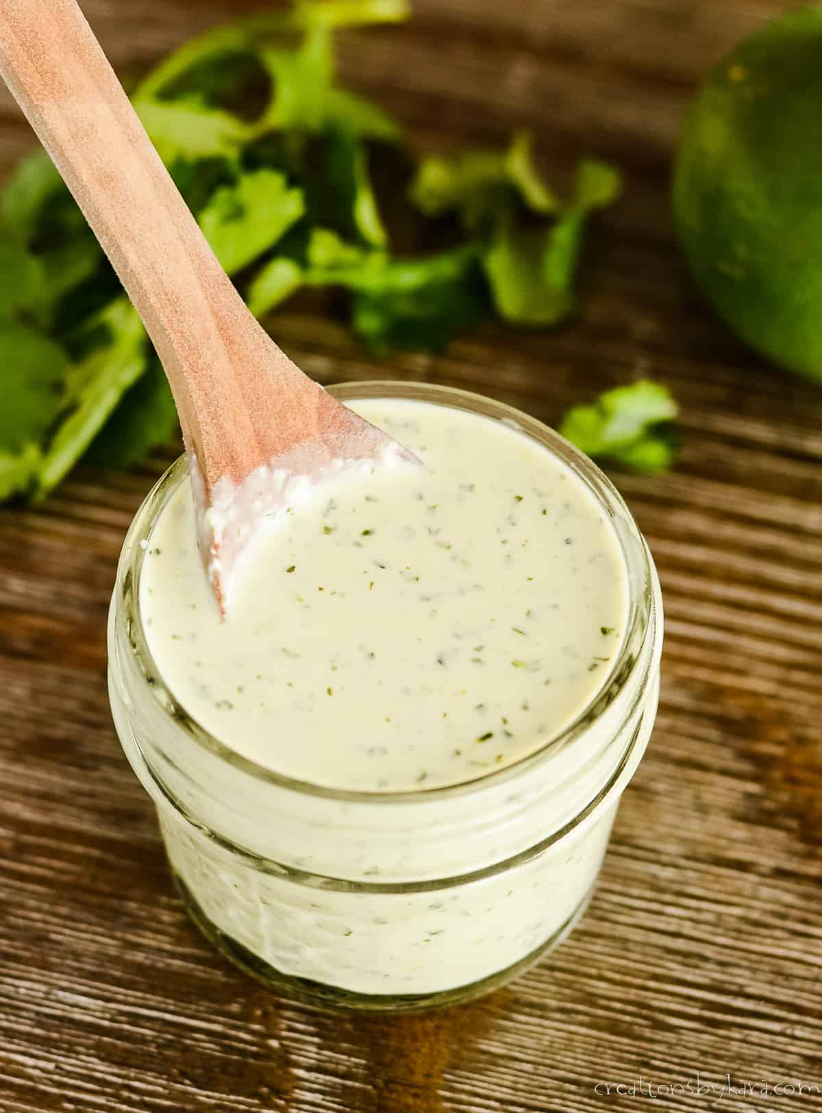 jar of creamy cafe rio dressing with a wooden spoon in it