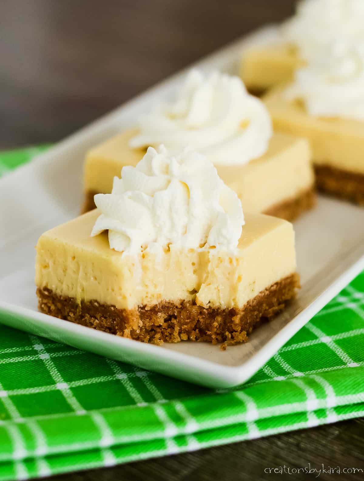 close up of key lime pie bar topped with whipped cream